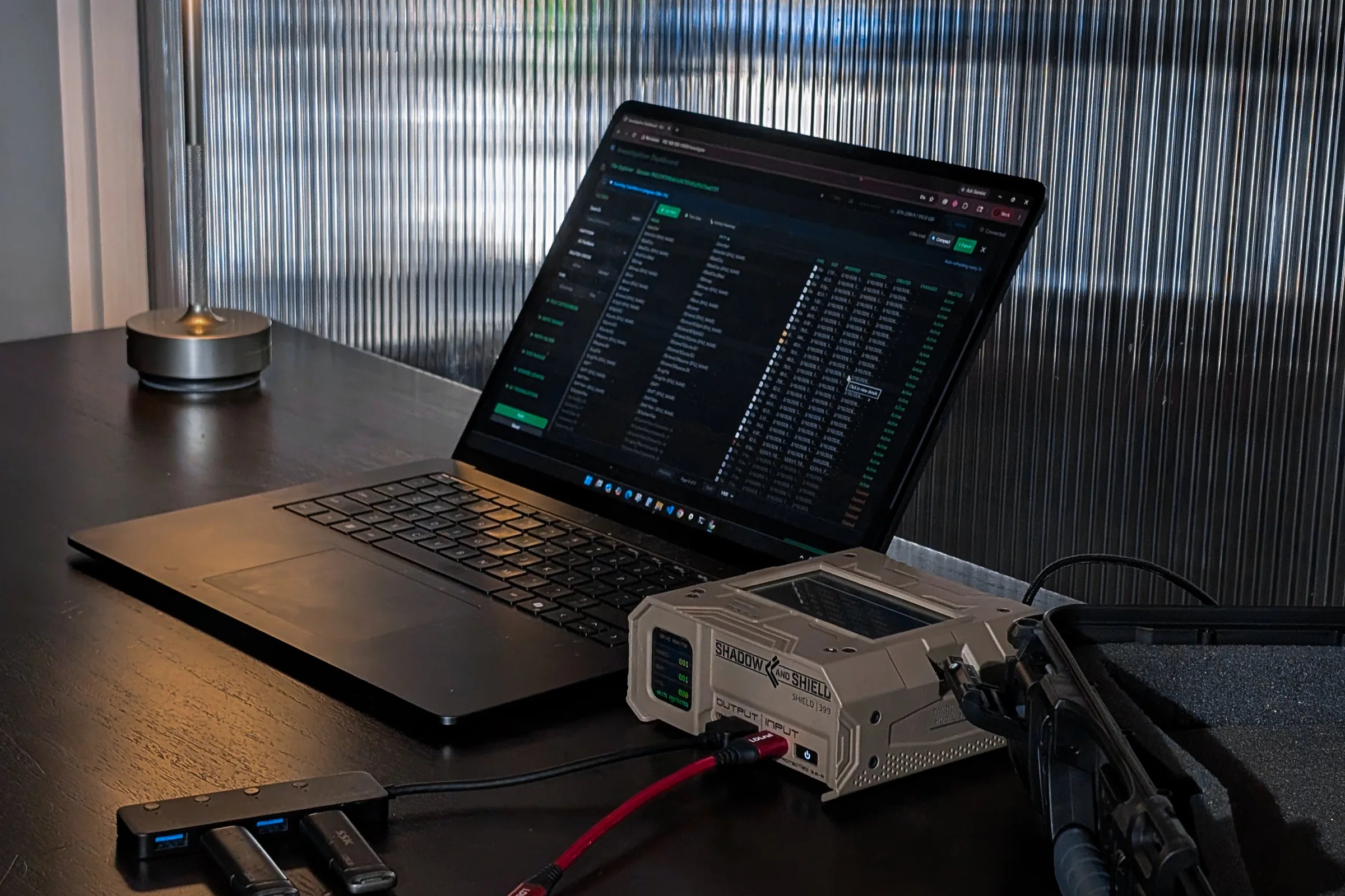 Shield-399 unit connected to media beside a laptop displaying the dashboard